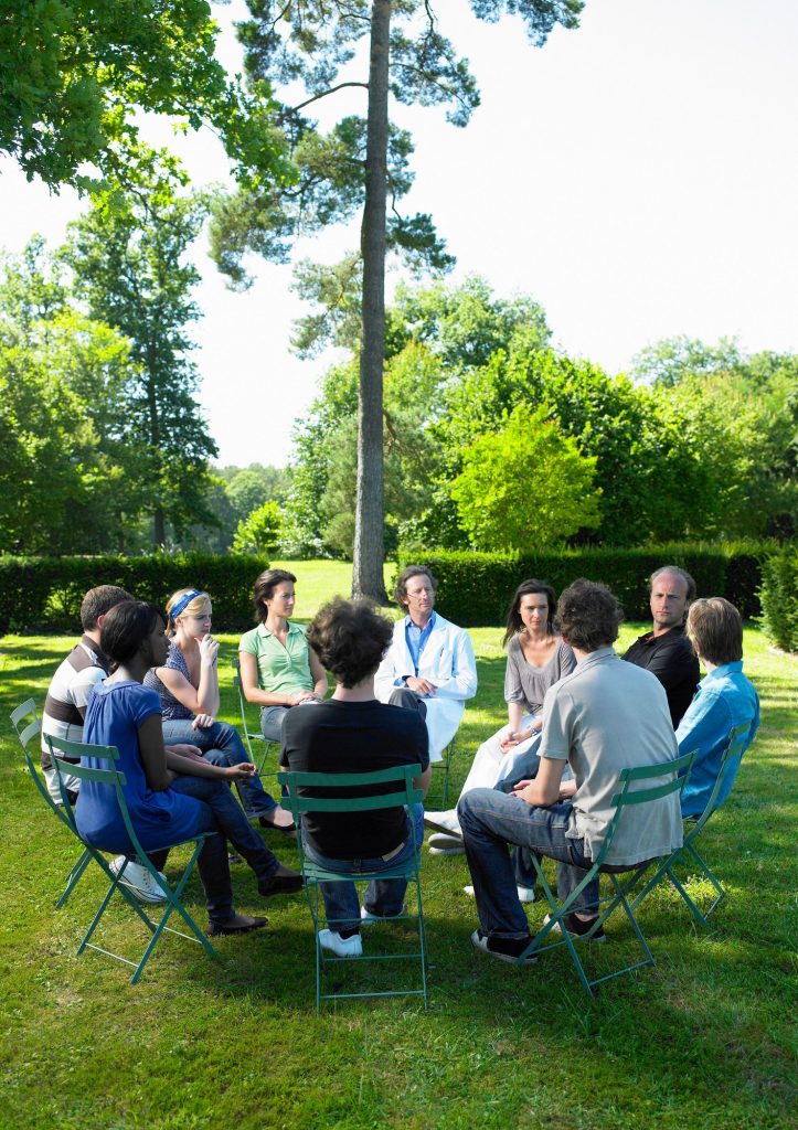 Circle of people in rehab, outdoors