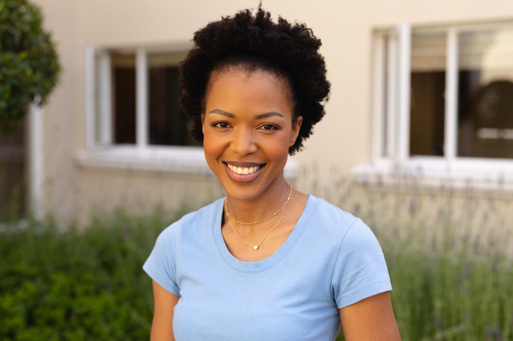 Close-up portrait of smiling african american young woman smiling while standing outdoors